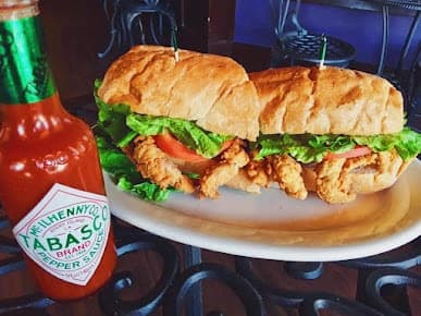 A soft-shell crab po-boy with lettuce and tomato, shared by Café Nola on Google Maps